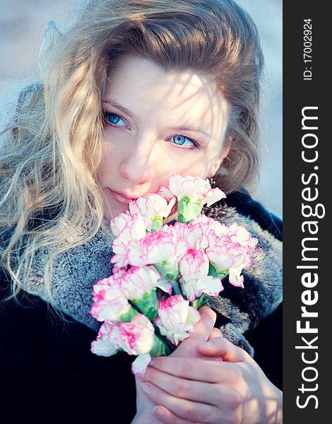 Closeup portrait of beautiful young girl in winter day wiht flowers