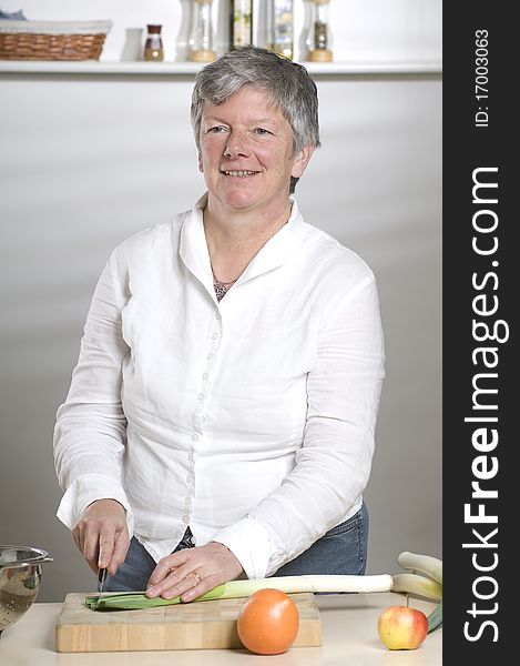 Women is cutting leek in the kitchen