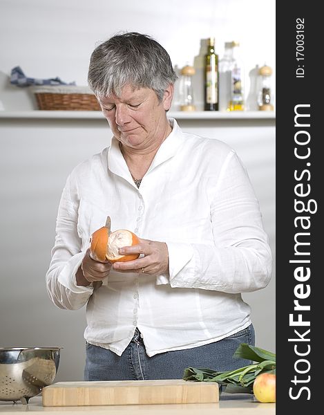 Women is peeling a Orange in the kitchen