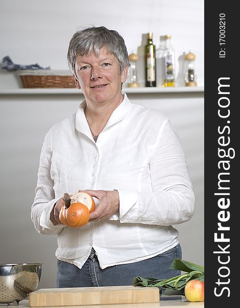 Women is peeling a Orange in the kitchen