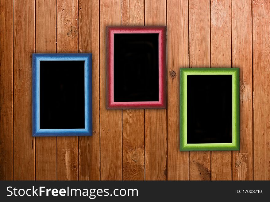 Three colorful frames hanging on wooden wall. Three colorful frames hanging on wooden wall