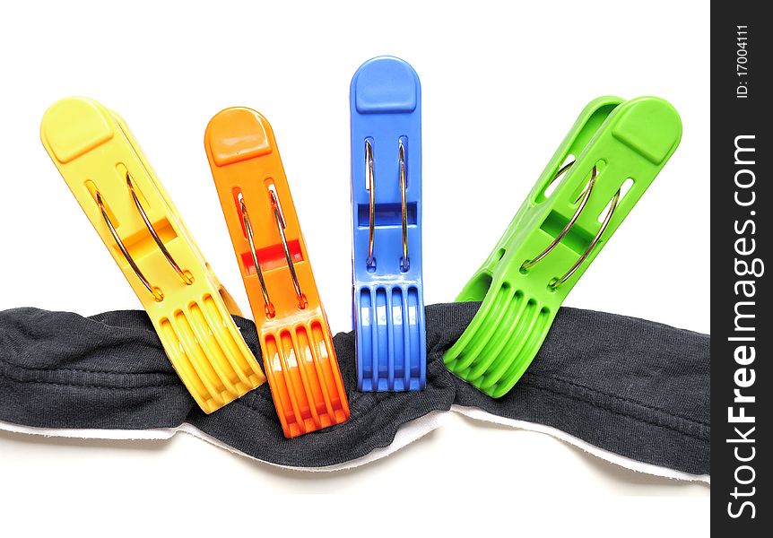 Four colorful clothes pegs and black t-shirt over white background. Four colorful clothes pegs and black t-shirt over white background