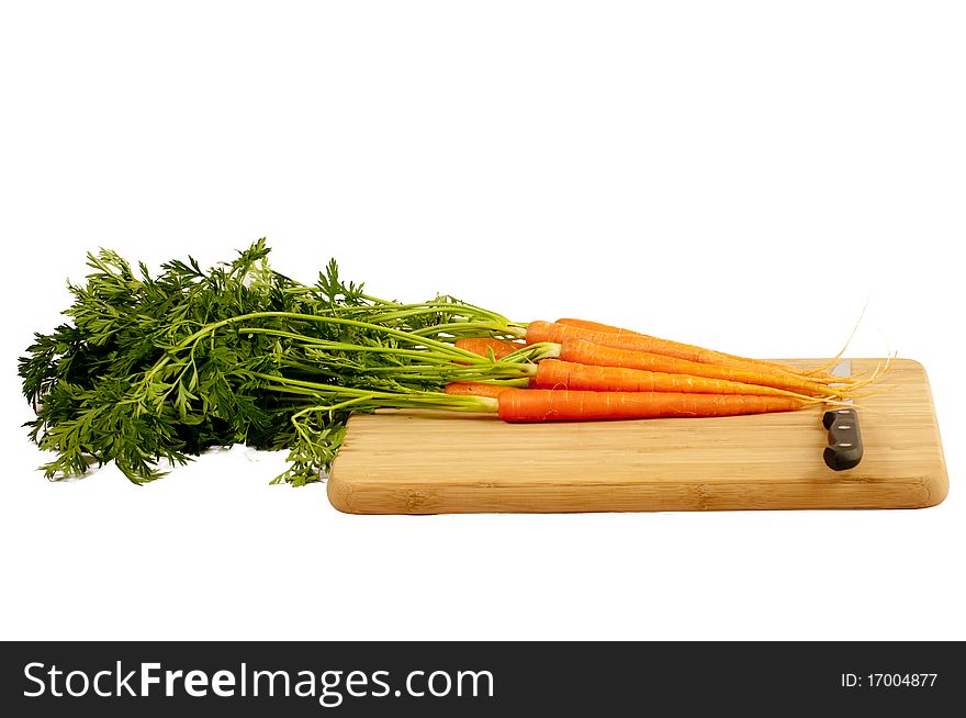 Carrots with knife on a wooden cutting board