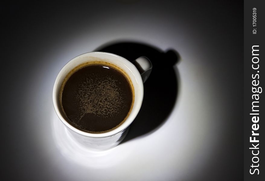 Black coffee in white cup on dark background