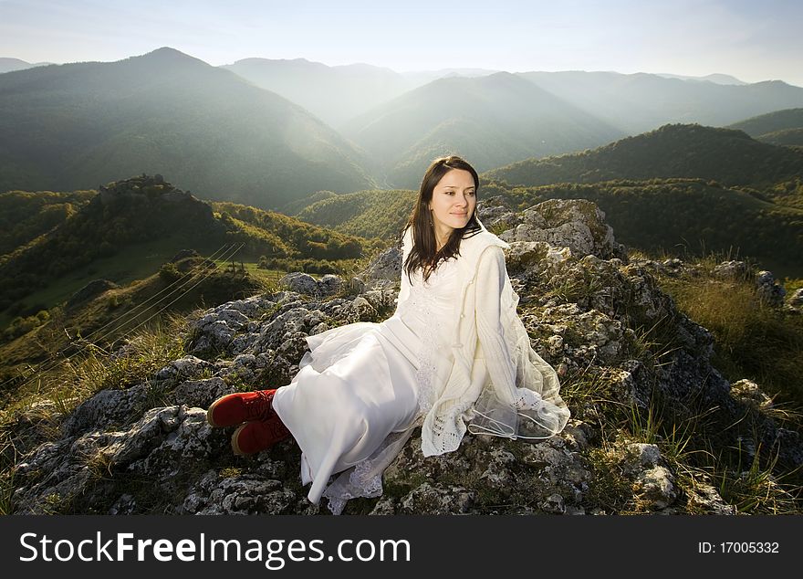 Beautiful bride posing on rocks in high mountain scenery. Beautiful bride posing on rocks in high mountain scenery