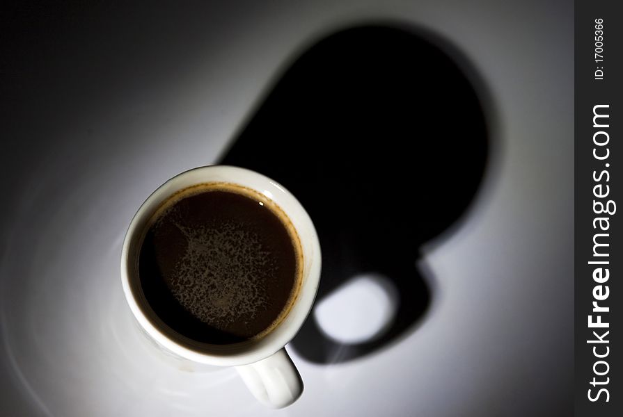 Black coffee in white cup on dark background