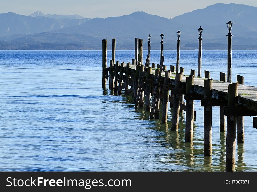 Jetty at lake Chiemsee in autumn with view of the bavarian alps, Germany