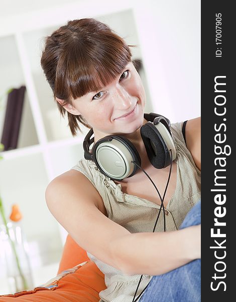 Young woman relaxing with earphones on sofa. Young woman relaxing with earphones on sofa