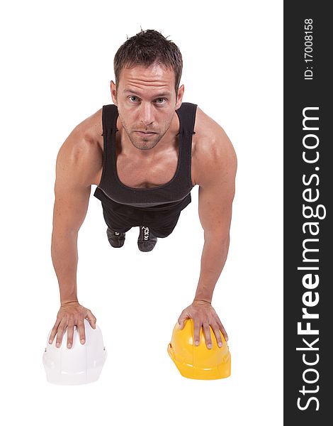 A man doing pushups on a yellow and white hard hats. A man doing pushups on a yellow and white hard hats.