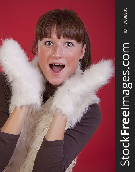 Surprised woman in white winter gloves over red background. Surprised woman in white winter gloves over red background