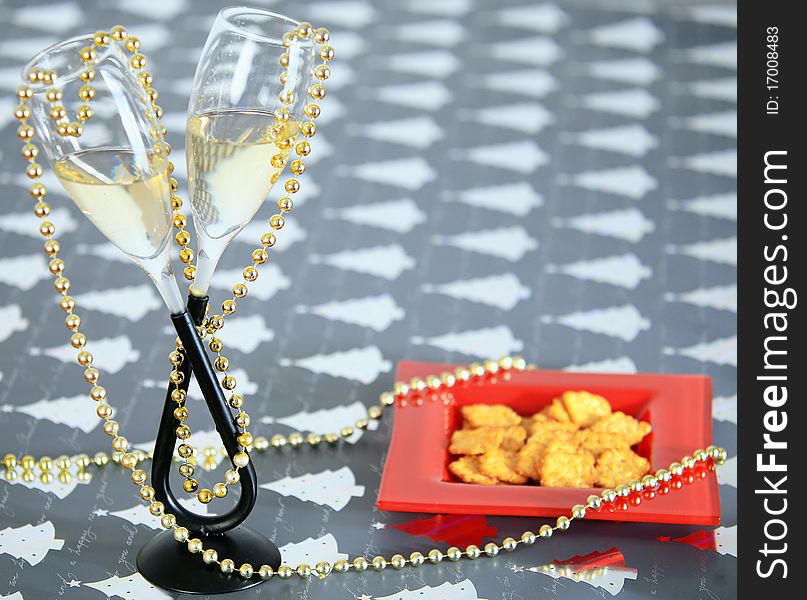 Glass of champagne with some snack in a red plate. Glass of champagne with some snack in a red plate