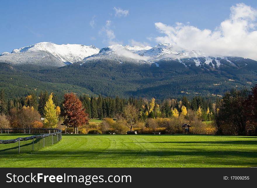 The early autumn snow on the top of the mountains viewed from nearby park. The early autumn snow on the top of the mountains viewed from nearby park