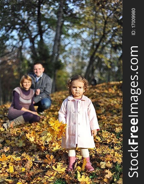 Happy family, mom and dad and little girl with a bouquet made from leaves. Happy family, mom and dad and little girl with a bouquet made from leaves