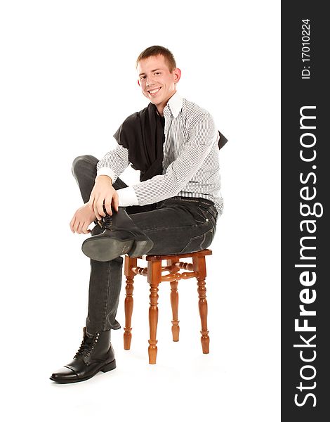 The serious man sitting on a chair and smiling against a white background. The serious man sitting on a chair and smiling against a white background.