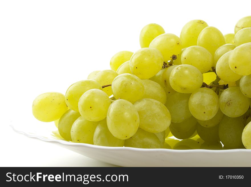 Grape bunch on the plate fragment isolated over white background (macro shot). Grape bunch on the plate fragment isolated over white background (macro shot)
