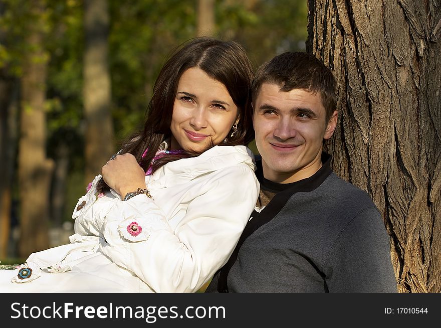 Young couple portrait over defocused autumn park background. Young couple portrait over defocused autumn park background
