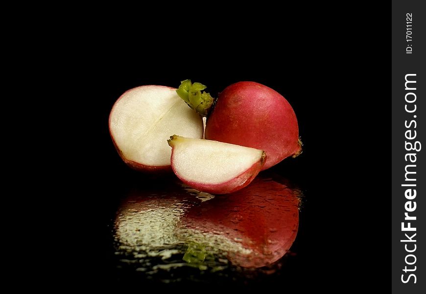 Radish on the black background with water drops