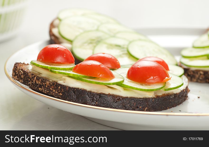 Rye bread with sliced tomatoes, cucumbers and cheese on plate. Rye bread with sliced tomatoes, cucumbers and cheese on plate