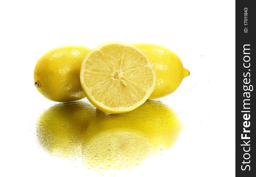 Fresh lemons on the white background with water drops