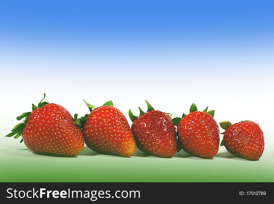 And ripe red strawberries on a colored background