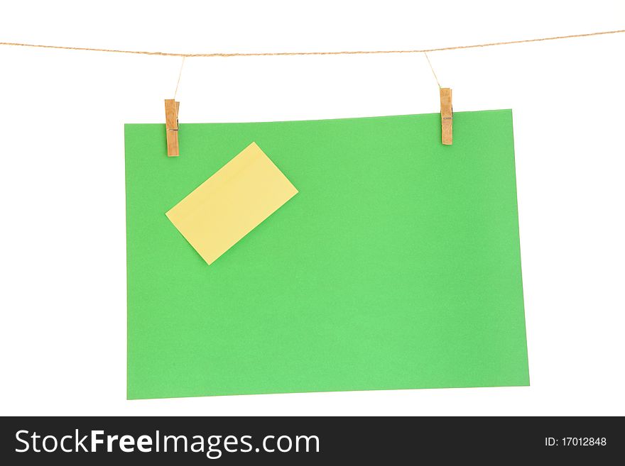Green blank paper sheet on a clothes line. Isolated on white background. Green blank paper sheet on a clothes line. Isolated on white background.