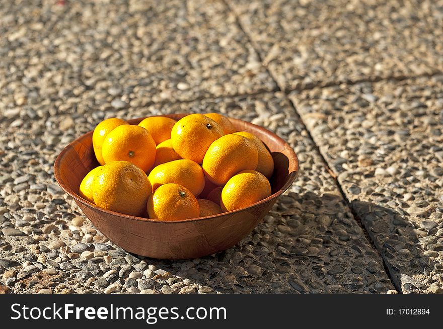 Fresh oranges in a wooden bowl
