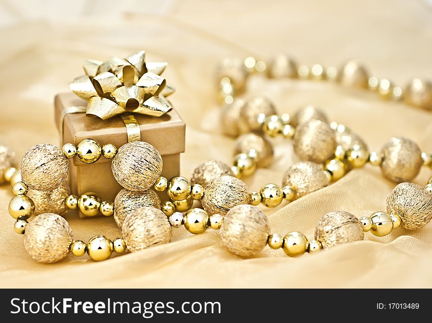 The gold background gold gift box with a string of Christmas ornamental ball. The gold background gold gift box with a string of Christmas ornamental ball.