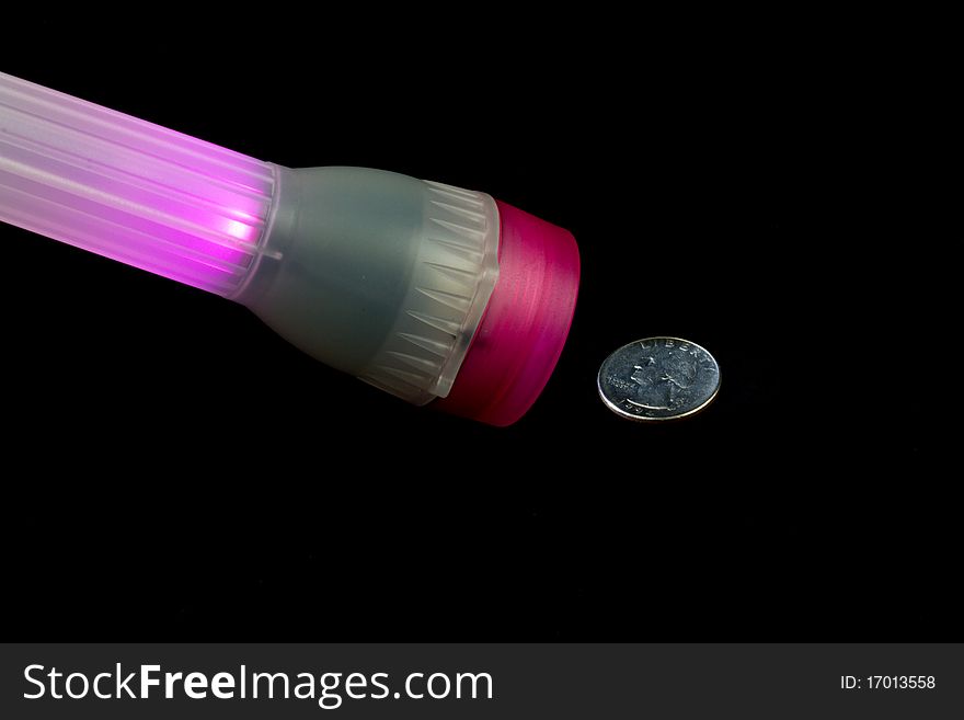 This is an image of a flashlight lighting up a quarter. This is an image of a flashlight lighting up a quarter.