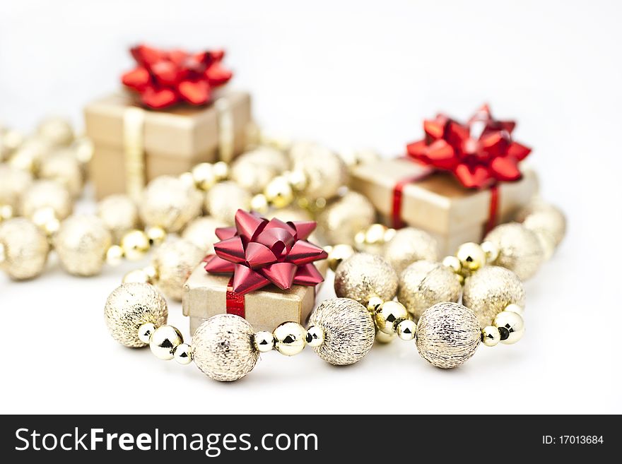 On a white background golden gift box with red tassels of golden ball strings. On a white background golden gift box with red tassels of golden ball strings.