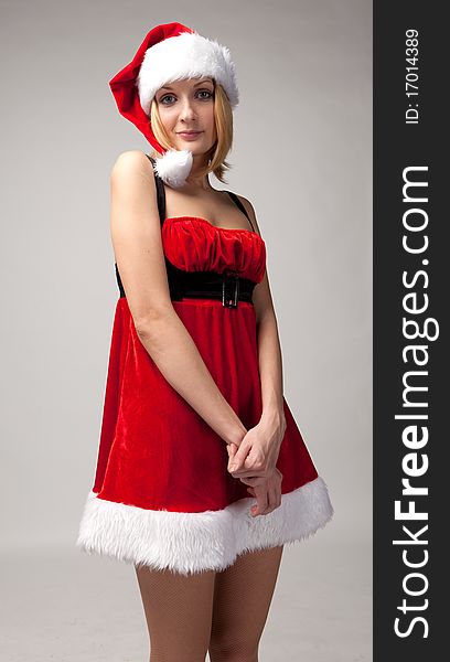 Christmas girl in santa hat on gray background