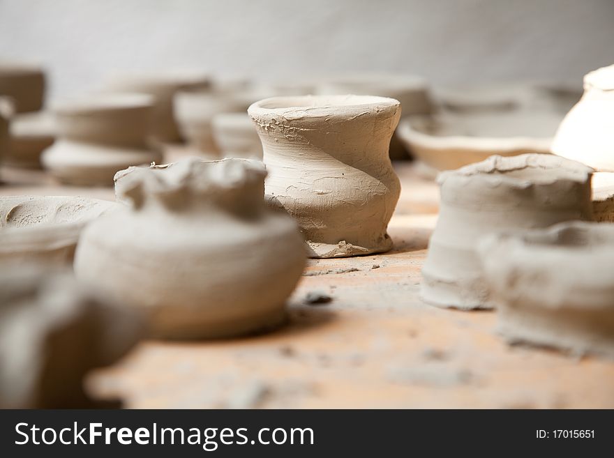 Primitive unpainted clay pots on a table. Primitive unpainted clay pots on a table