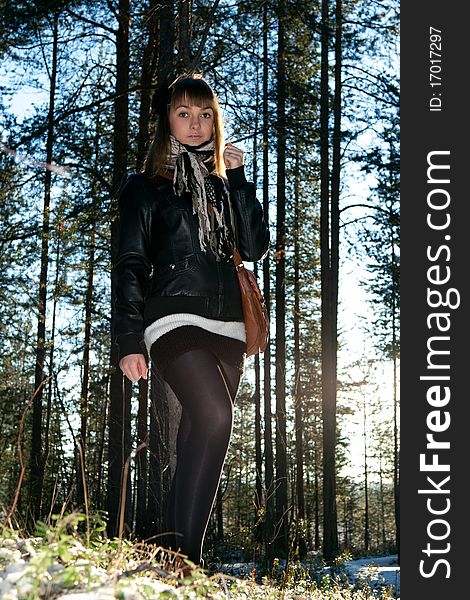 Young beautiful girl in black jacket in wood