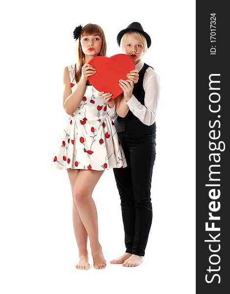 Two girls with red cardboard heart on white background