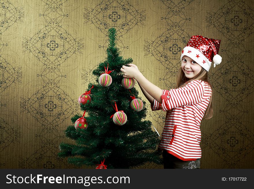 A little girl decorating a new year tree with balls. A little girl decorating a new year tree with balls