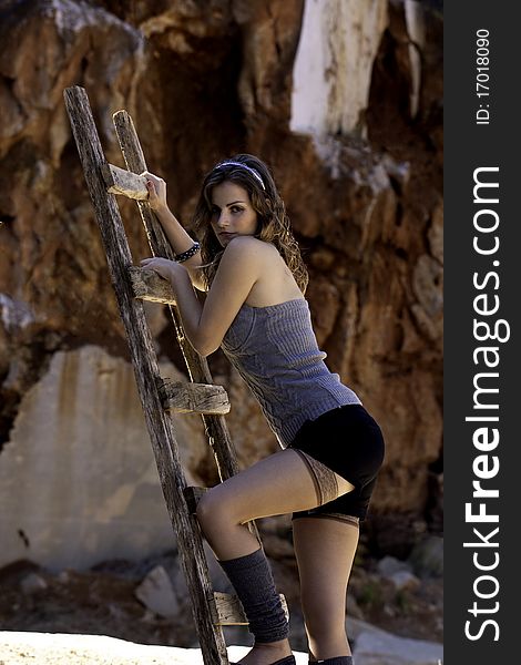 View of a beautiful woman, climbing some wooden stairs, sustained on the middle air. View of a beautiful woman, climbing some wooden stairs, sustained on the middle air.