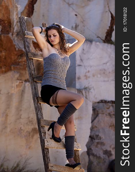 View of a beautiful woman, climbing some wooden stairs, sustained on the middle air. View of a beautiful woman, climbing some wooden stairs, sustained on the middle air.