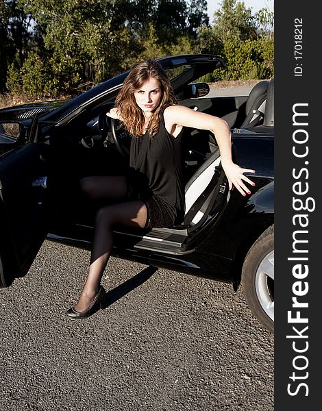 View of a beautiful woman exiting a sports car. View of a beautiful woman exiting a sports car.