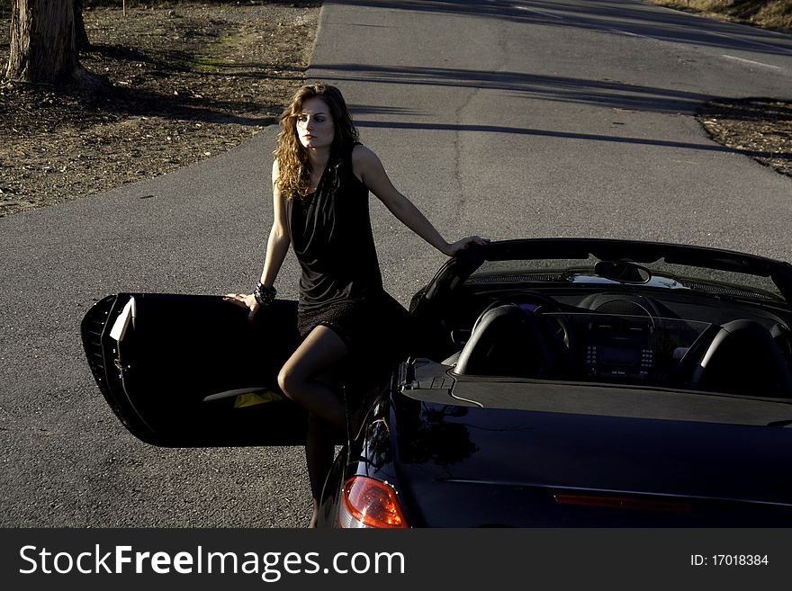 View of a beautiful woman exiting a sports car. View of a beautiful woman exiting a sports car.