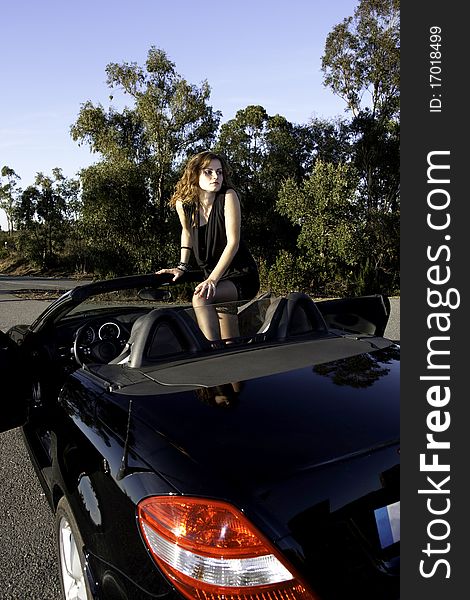 View of a beautiful woman inside a sports car. View of a beautiful woman inside a sports car.