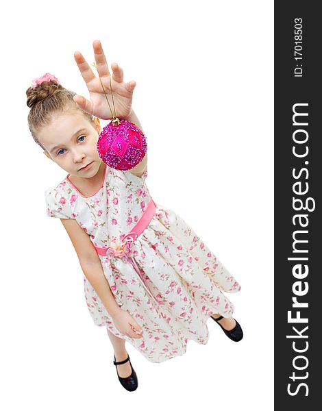 High angle view of a little cute girl playing with a tree-decoration ball. High angle view of a little cute girl playing with a tree-decoration ball