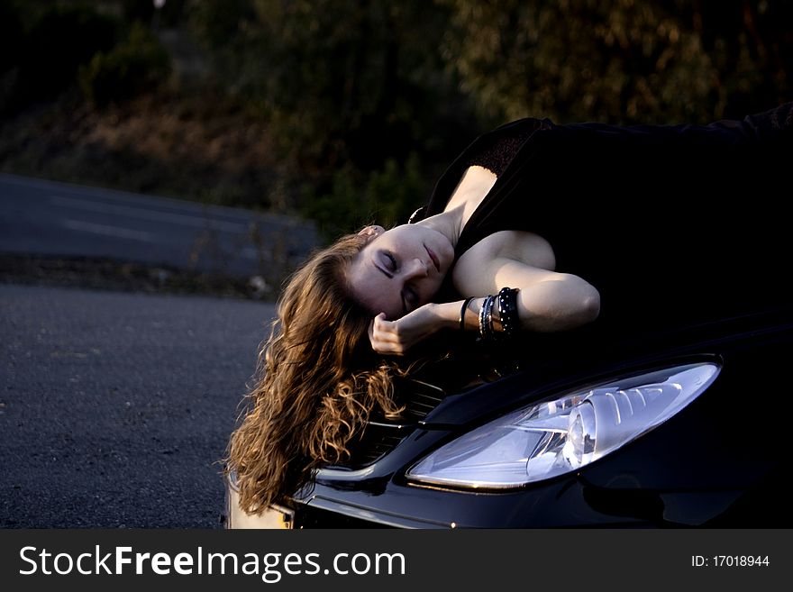 View of a beautiful woman on top of a sports car. View of a beautiful woman on top of a sports car.