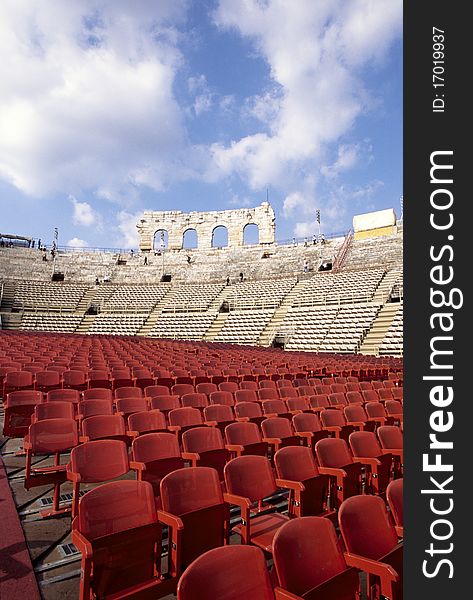 Rows of red chairs in the midlle of a coloseum.