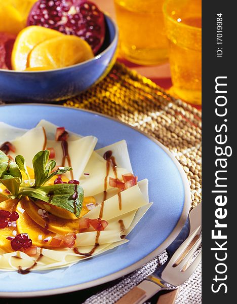 Carpaccio on blue plate with decoration in the background.