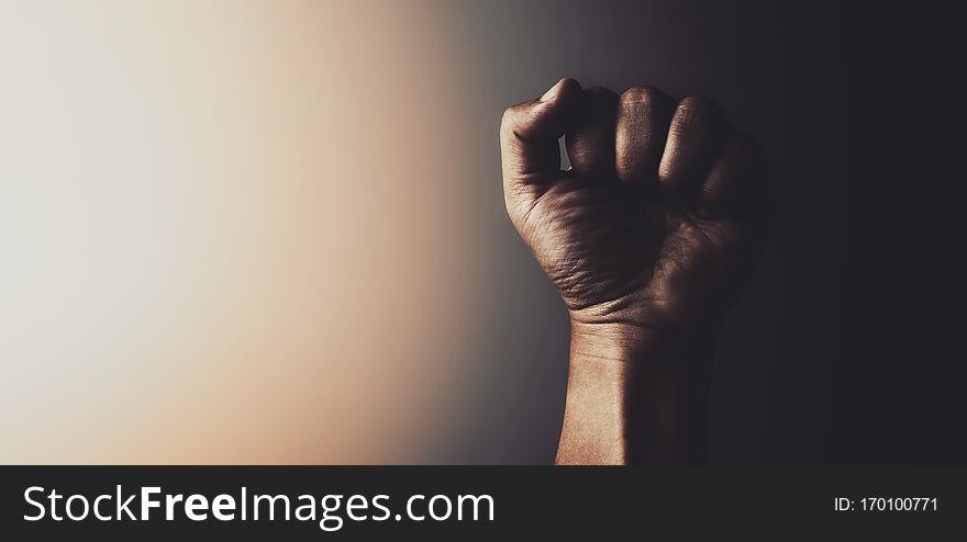 Fist of male hand with light in vintage tone background. Fist of male hand with light in vintage tone background