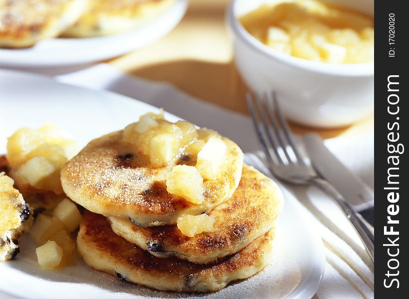 Sweet curd cheese fritters on a plate with flatware