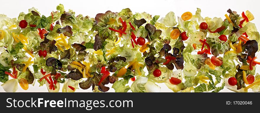 Long strip of salad leaves on white background.