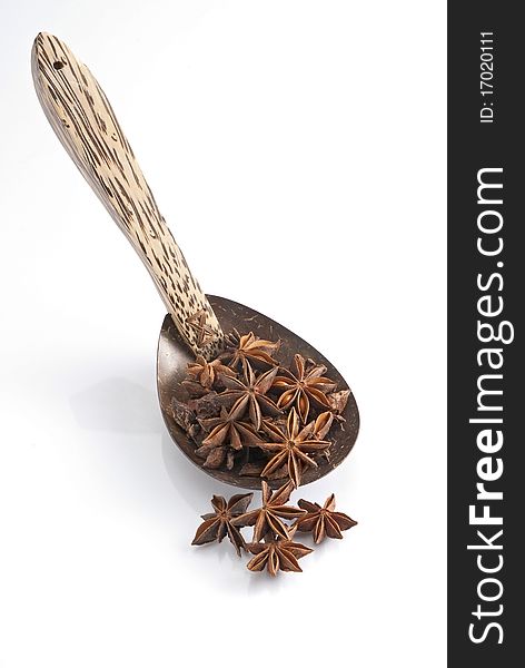 Isolated wooden Spoon with on star  anise it. Isolated wooden Spoon with on star  anise it.