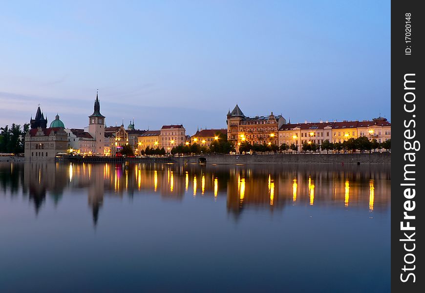 Prague riverbank on sunset with reflection on water