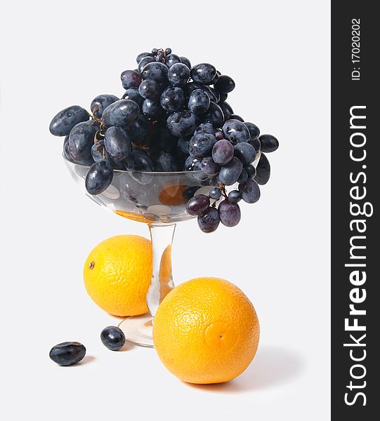 Black Grapes In A Vase And Oranges