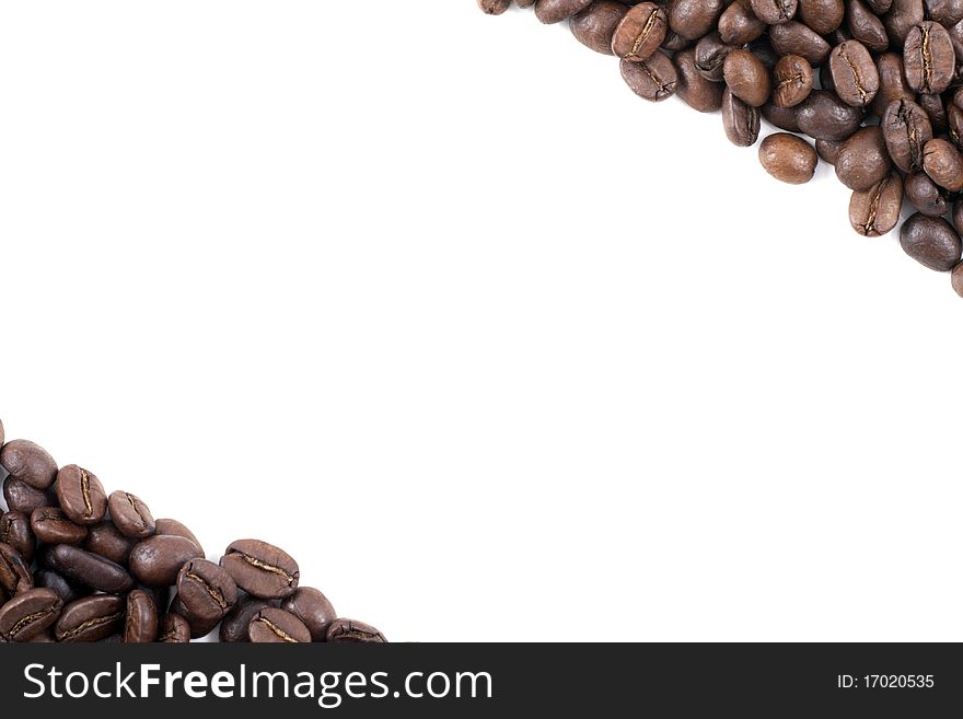 Frame of dark roasted coffee beans in the corners on a white background